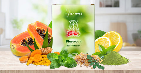 Verpackung von VITAmyne Floracur mit Bärenmotiv, Inhaltsstoffe im Hintergrund