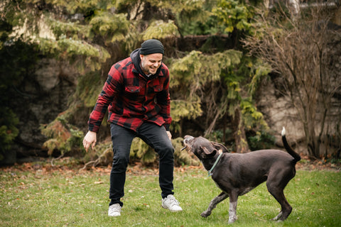 Aktiver Mann spielt mit seinem Hund – mehr Lebensfreude und Beweglichkeit dank VITAmyne Arthro bei Gelenkbeschwerden